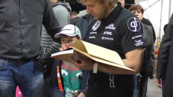 Lithuanian Dakar rally driver Vanagas signing his book — Stock Video