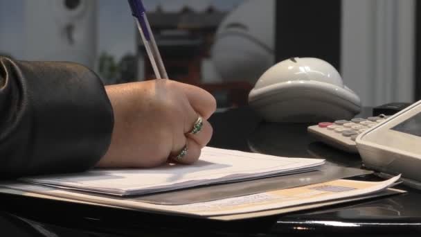 Рука женщины пишет на листе бумаги — стоковое видео