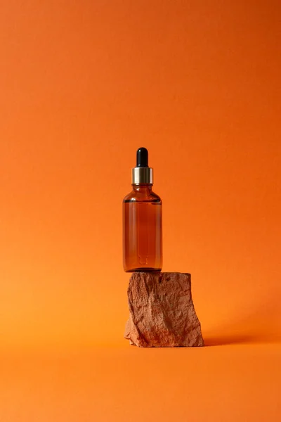 Borostyánsárga palack fémes fedéllel egy darab kövön — Stock Fotó