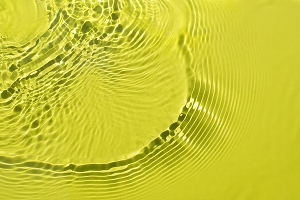 Water spills on a light green yellow background. — Stock Photo, Image