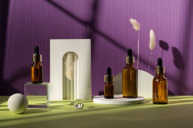 Turuncu ve menekşe arkaplan üzerinde son moda geometrik şekillere sahip dört kehribar cam şişe..