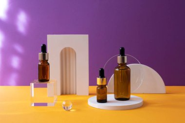 Turuncu ve menekşe arkaplan üzerinde son moda geometrik şekilli üç kehribar cam şişe..