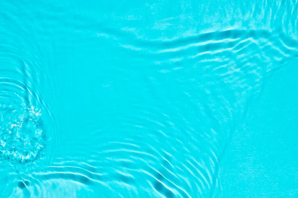 Acqua fuoriesce su uno sfondo azzurro. — Foto Stock