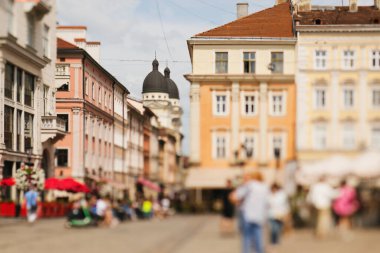 Eski şehir manzaralı doğal bir bokeh, odak arkaplanı bulanık. Mesaj veya reklam için soyut ve güzel bir arkaplan. Odaklanmamış kafeler, binalar ve insanlar