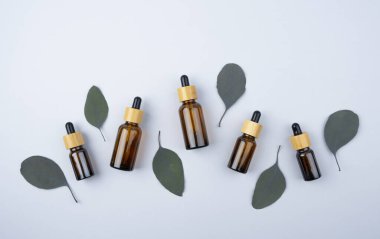 Amber cam damlaları farklı boyutlarda ve bambu kapaklı ve okaliptüs yapraklı kavanozlar..