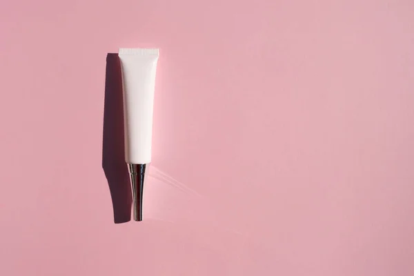 Plástico creme olho tubo branco com tampa de metal e ponta estreita. Vista superior sobre fundo lilás. — Fotografia de Stock
