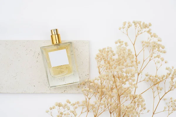 白い背景に石皿の上に香水の透明なボトル。昼の香りのプレゼンテーション. — ストック写真
