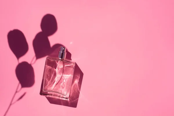 Transparent bottle of perfume ona pink background. Fragrance presentation with daylight — Stock Photo, Image