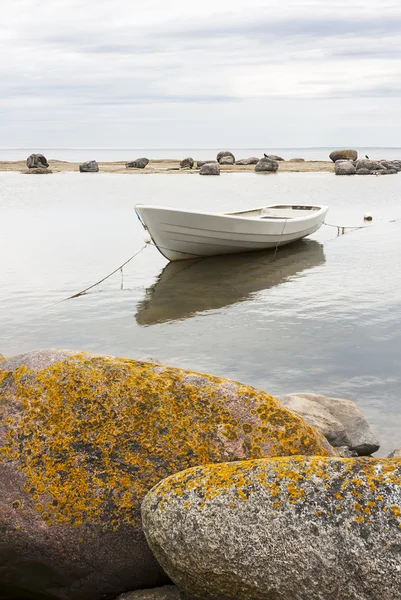 White boat behind rocks — Stock Photo, Image