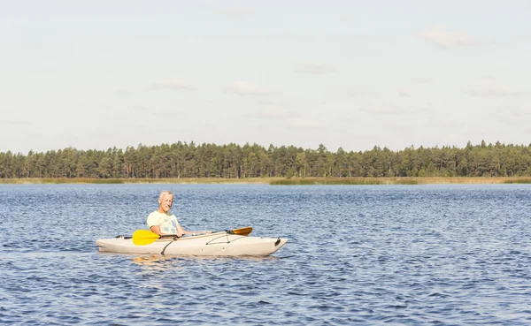 Homem está dirigindo caiaque na água — Fotografia de Stock