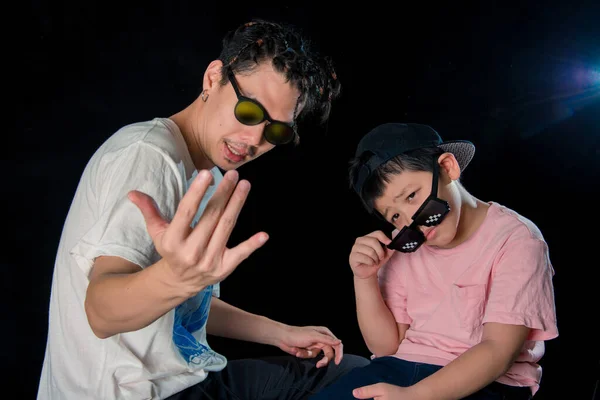 男と男の子とともにサングラス座っているカメラオンダークスタジオ背景 アジアの家族 — ストック写真