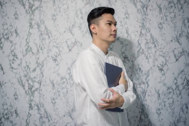 Yakışıklı gülümseme elinde bir defter ve ofiste gülümsüyor.