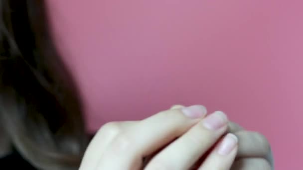 Gadis memegang untai tampilan depan rambut pada latar belakang merah muda, konsep rambut rontok — Stok Video
