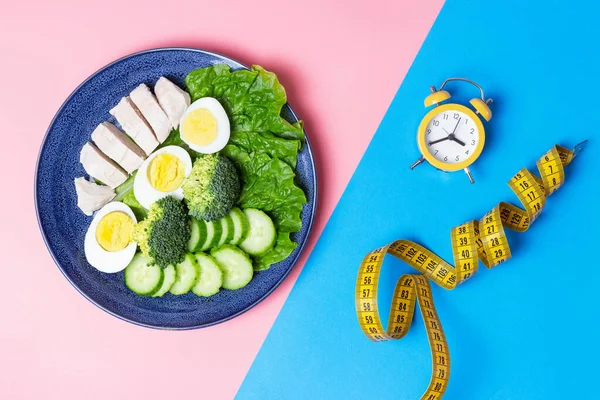 Essen Und Wecker Auf Blauem Und Rosa Hintergrund Intermittierendes Fastenkonzept — Stockfoto