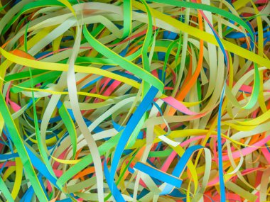Abstract background close up colorful holiday paper ribbons.Celebration serpentine.Bunch of green,blue,pink,yellow curly mixed tapes,streamers.Concept of congratulation,festive event,fun.Copy space