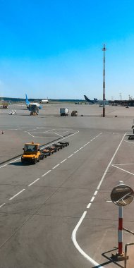 Moskova, Rusya-Haziran 03.2021: Sahada çalışan Dikey Sheremetyevo uluslararası havaalanı hizmetleri. Ayakta duran hava araçlarıyla havaalanı manzarası, bagaj teslimatı için boş bir kamyonun yanından geçmek..