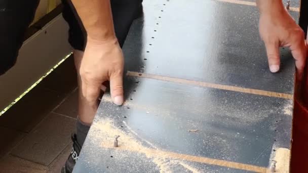 在家里的阳台上用木匠的铅笔勾勒出一块画板的轮廓 用电锯锯断它 去掉它 — 图库视频影像