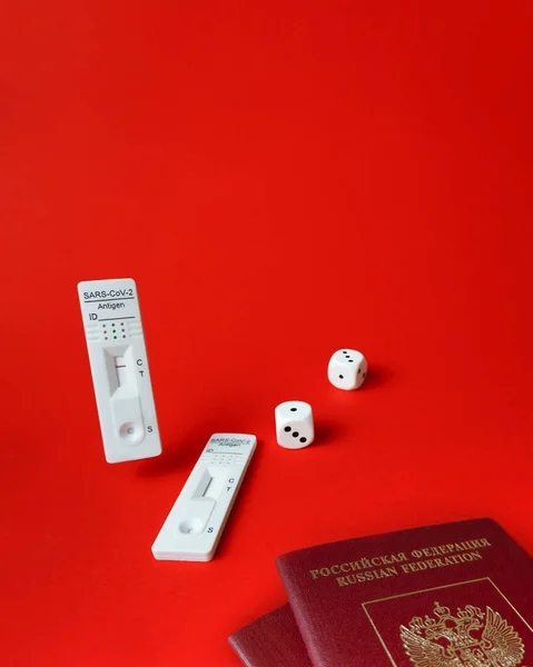 Rapid SARS-Cov-2 Antigen Test,negative result,unused,dice on red,pair of tourist passport.Concept of bad or good luck for traveller crossing borders,two-week quarantine.Play game with fate,copy space.