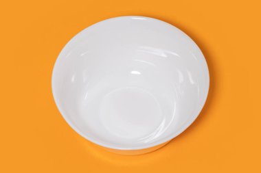 Sarı arka planda beyaz seramik kase.