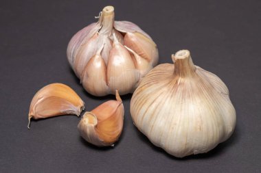 Sarımsak karanfili, koyu bir arka planda sağlıklı bir baharata dönüşür..