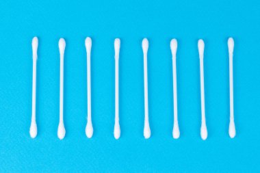 Mavi arkaplanda beyaz pamuklu çubuklar