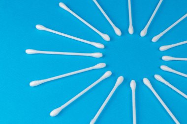 Mavi arkaplanda beyaz pamuklu çubuklar