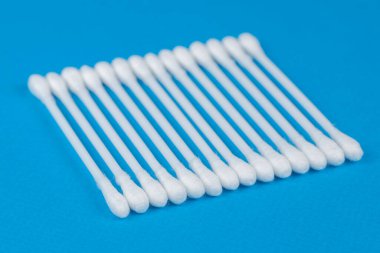 Mavi arkaplanda beyaz pamuklu çubuklar