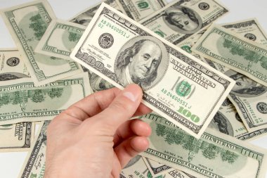 Elinde bir dolarlık bir banknot var..