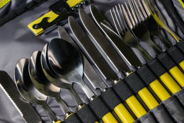 Sırt çantasında piknik seti. Bıçaklar kaşıkları çatallar.