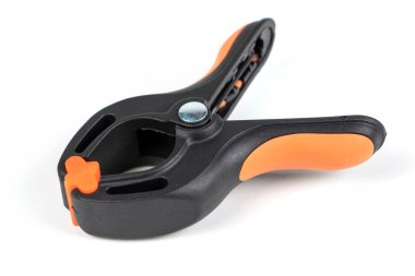 Plastik yay kıskacı beyaz arkaplanda izole edilmiş. Kıskaç ekipmanı. Çalışan el aleti. Siyah ve turuncu yay kıskacı. Yakın çekim..