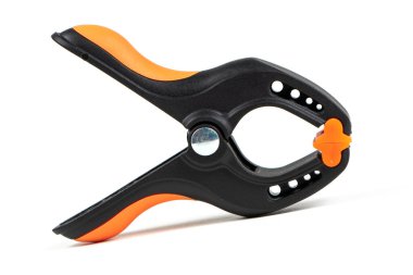 Plastik yay kıskacı beyaz arkaplanda izole edilmiş. Kıskaç ekipmanı. Çalışan el aleti. Siyah ve turuncu yay kıskacı. Yakın çekim..