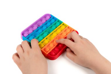 Gökkuşağıyla oynayan çocuk parmaklarıyla baloncuklara bastırıyor, üst perdede. Çocuklar ve yetişkinler için yeni stres önleyici oyuncaklar. Metin veya tasarım için boşluk kopyala.