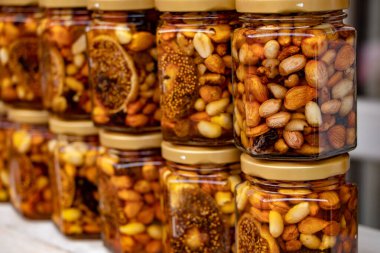 Kavanozda meyve ve fındıklı renkli bal.