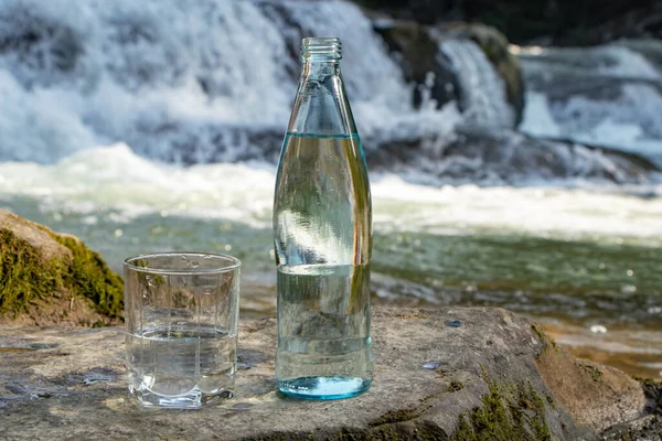 Натуральная Питьевая Вода Бутылке Стакане Природном Фоне Реки — стоковое фото