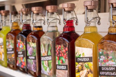 Yaremche Ukrayna. 25 Haziran 2021: Raflarda el yapımı likör ve bal bulunan şişeler. Farklı meyve ve meyvelerden alınan alkollü içecekler.