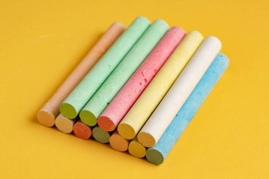 Sarı arkaplanda renkli tebeşirler.