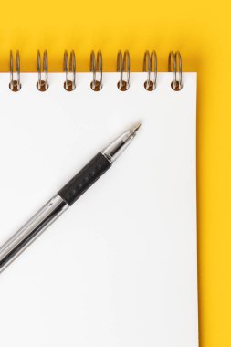 Sarı zemin üzerinde kalem olan boş not kağıdı.