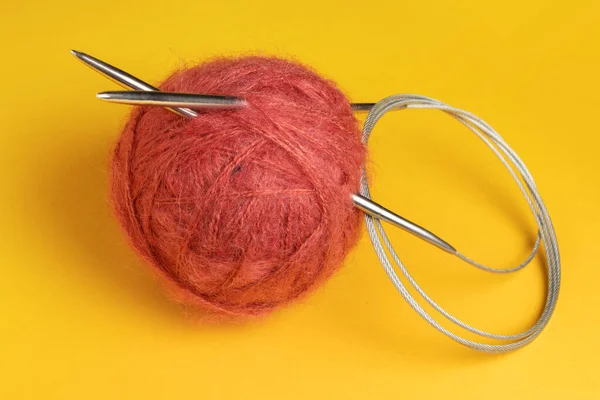 黄色の背景に針で編む糸のボール — ストック写真