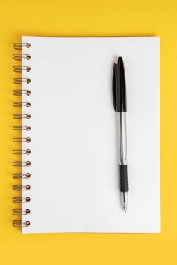 Sarı zemin üzerinde kalem olan boş not kağıdı.