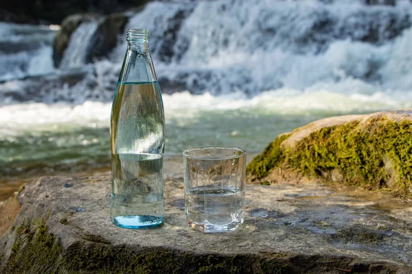 Натуральная Питьевая Вода Бутылке Стакане Природном Фоне Реки — стоковое фото