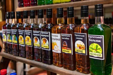 Yaremche Ukrayna. 25 Haziran 2021: Raflarda el yapımı likör şişeleri. Farklı meyve ve meyvelerden alınan alkollü içecekler.