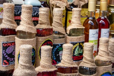 Yaremche Ukrayna. 25 Haziran 2021: Raflarda el yapımı likör şişeleri. Farklı meyve ve meyvelerden alınan alkollü içecekler.