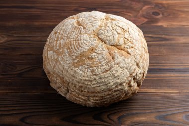 Yuvarlak, taze ev yapımı ekmek, altın gibi çıtır çıtır. Ekmeğin yüzeyinde kırsal cazibesine eklenen karakteristik kesikler var..