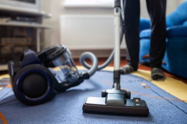 Halıyı elektrikli süpürgeyle temizleyen adam, yakın plan..