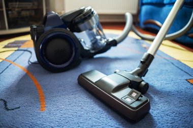 Odada halı fırçası olan modern elektrikli süpürge..