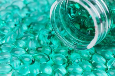 Kabukta sıvı vitaminli mavi kapsüller. Eklem dişleri ve kemikler için beslenme takviyesi içeren mavi kapsüller..