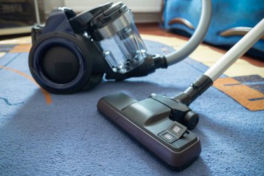 Halıda modern elektrik süpürgesi var..