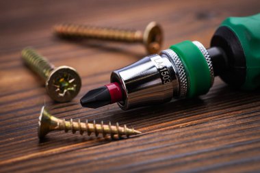 Tornavida ve tahta arka planda vidalar. Kendini beceren vida. Makro fotoğrafı vidalıyor. Yapı soyut. Sanayi geçmişi.