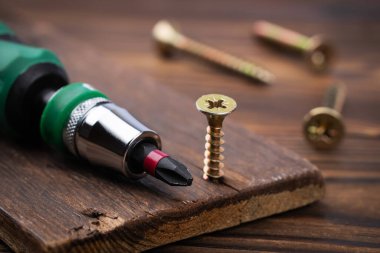 tornavida ve vidalar ahşap arka planda kapat.