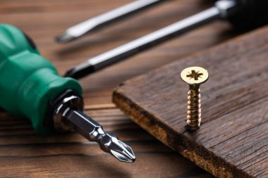 Tornavida ve tahta arka planda vidalar. Kendini beceren vida. Makro fotoğrafı vidalıyor. Yapı soyut. Sanayi geçmişi.